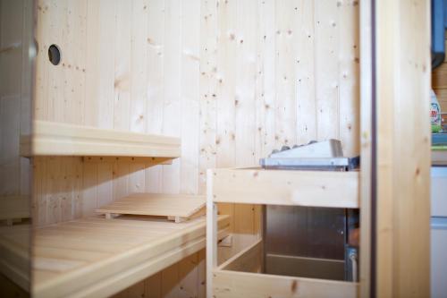 a sauna with wooden walls and wooden shelves at Domki Luksusowe Eskada in Ustronie Morskie