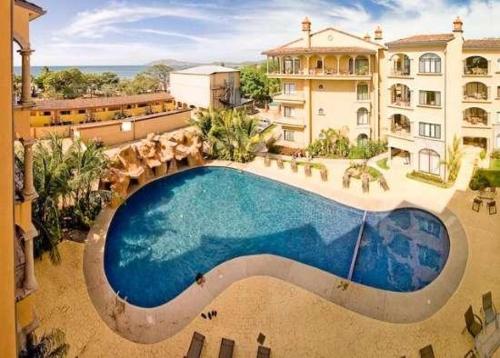 an overhead view of a swimming pool in front of a building at Stay in Tamarindo Condominiums in Tamarindo