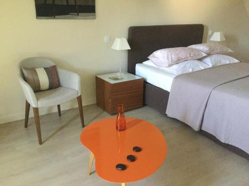 a bedroom with a bed and a table and a chair at Chambres d'Hotes au Pays de Valencay en Berry in Valençay