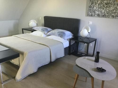 um quarto com uma cama com duas mesas e dois candeeiros em Chambres d'Hotes au Pays de Valencay en Berry em Valençay