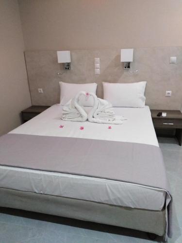 a white bed with two towels on top of it at 7 Islands in Alykes