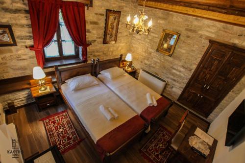 a bedroom with a large bed and a window at Hotel Kastro in Gjirokastër