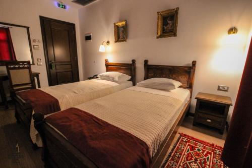 two beds in a hotel room with at Hotel Kastro in Gjirokastër
