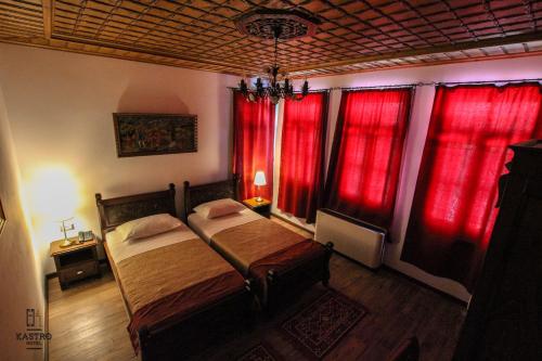 a bedroom with red curtains and a bed in it at Hotel Kastro in Gjirokastër
