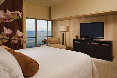 a hotel room with a bed and a flat screen tv at Four Seasons Hotel Seattle in Seattle