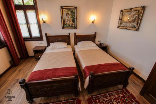 two beds in a small room with at Hotel Kastro in Gjirokastër