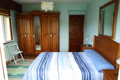 a bedroom with a large bed and wooden cabinets at CASA VACACIONAL NIÑONS-PONTECESO in Ponteceso