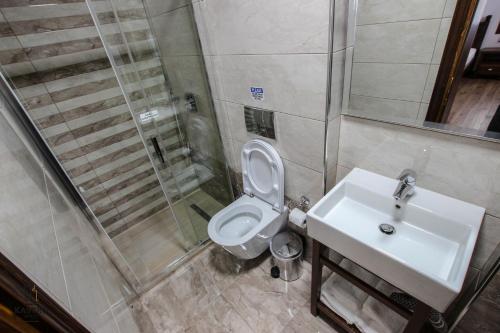 a bathroom with a toilet and a sink at Hotel Kastro in Gjirokastër