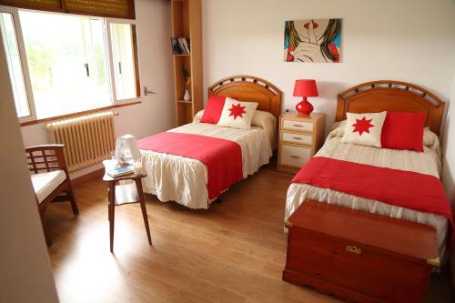 1 dormitorio con 2 camas con sábanas rojas y blancas en CASA VACACIONAL NIÑONS-PONTECESO, en Ponteceso