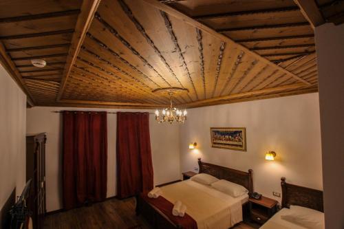 a bedroom with a bed and a wooden ceiling at Hotel Kastro in Gjirokastër