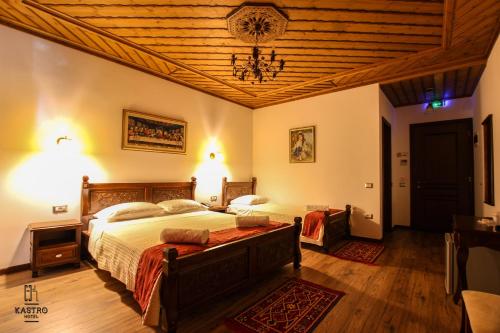 a bedroom with two beds and a wooden ceiling at Hotel Kastro in Gjirokastër
