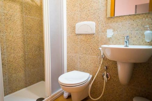 La salle de bains est pourvue de toilettes, d'un lavabo et d'une douche. dans l'établissement Paradise beb, à Giovinazzo