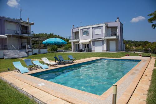 una piscina con sillas y una casa en Deep Purple House 2, en Kriopigi