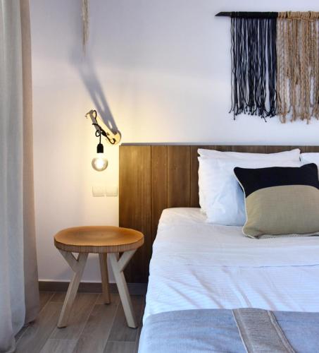 a bedroom with a bed with a table and a lamp at Angelos Boutique Suites in Patitiri