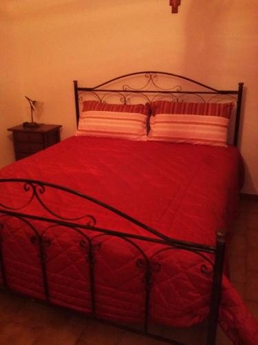 a bedroom with a red bed with a red comforter at Trulli in Valle D'Itria in Cisternino