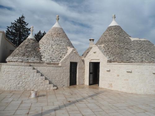 a group of three buildings with stone roofs at Trulli in Valle D'Itria in Cisternino