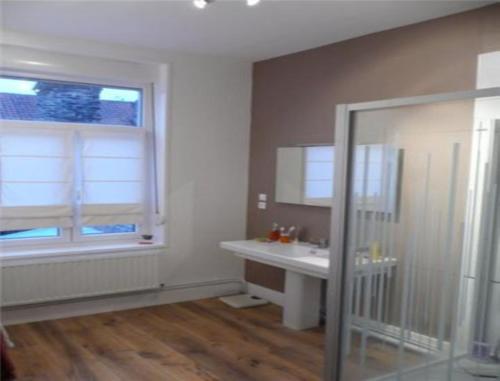 uma casa de banho com um lavatório, um espelho e uma janela em Bruneval House em Dunkerque