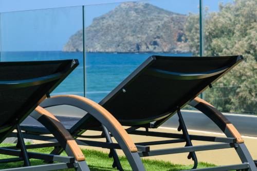a rocking chair sitting in front of a window at Platanias Aetheras Beach in Plataniás