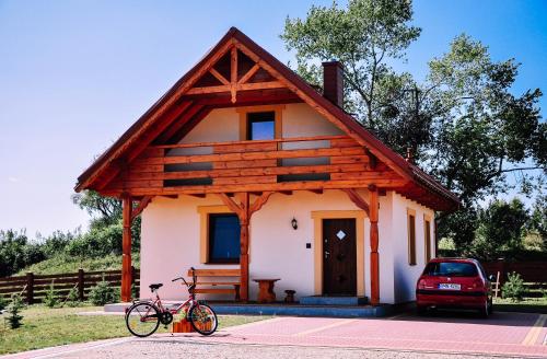a bike parked in front of a small house at Żwirowa Góra - Domki nad Narwią in Tykocin
