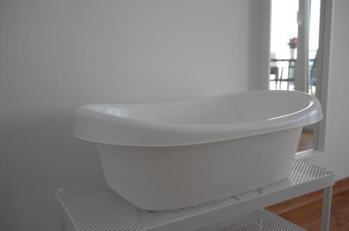a white stool sitting on a shelf in a room at Ocean View Suite in Paço de Arcos