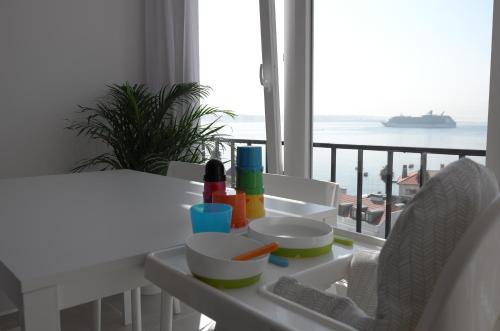 a white table with food and a view of the ocean at Ocean View Suite in Paço de Arcos