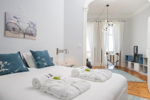 リスボンにあるLisbon Dreams Estrela TOP Suitesのベッドルーム1室(白いベッド1台、タオル付)