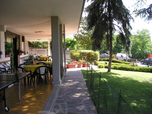a patio with a table and chairs in a yard at Hotel Astoria in Tabiano
