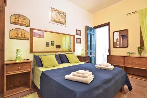 ポッツァッロにあるCasa Mare Holiday Pozzalloのベッドルーム1室(ブルーベッド1台、タオル付)