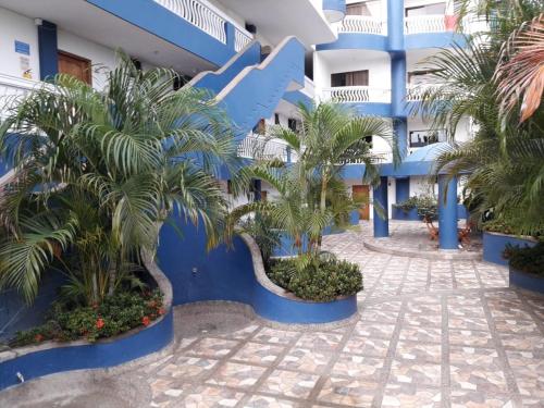 um edifício azul com palmeiras em frente em Edificio Mar de Leva em Santa Marta