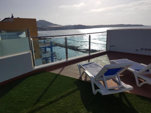 a balcony with two chairs and a view of the ocean at Casa Playa Ondina in Gáldar