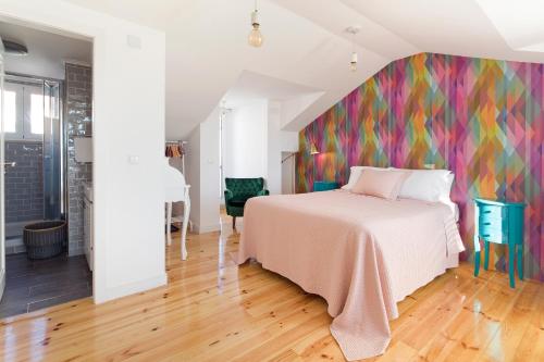 a bedroom with a bed and a colorful wall at FeelingLisbon Tejo in Lisbon