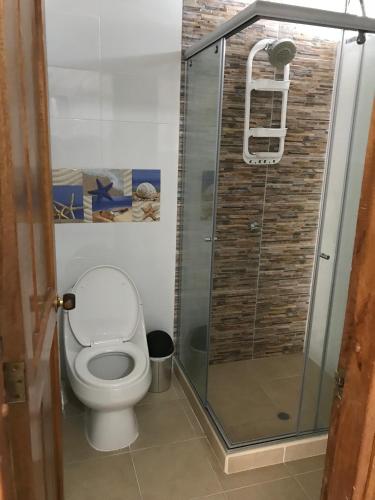a bathroom with a toilet and a glass shower at Edificio Mar de Leva in Santa Marta