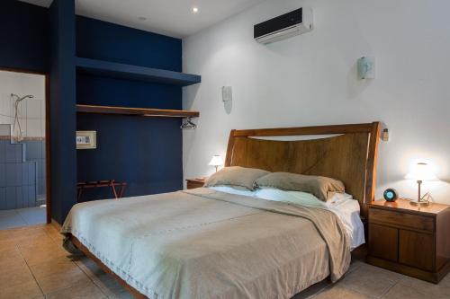 a bedroom with a large bed with blue walls at Villas Macondo in Tamarindo