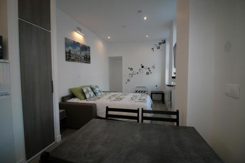 a bedroom with a bed and a table in it at Comme à la Maison - CENTRE-VILLE in Saint-Quentin