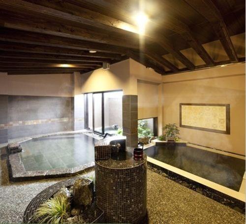une grande piscine intérieure dans un bâtiment dans l'établissement Silk Inn Kagoshima, à Kagoshima