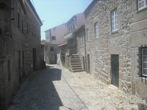 an alley in an old town with stone buildings at Casa do Beirado in Gouveia