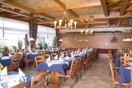 uma sala de jantar com mesas e cadeiras azuis em Hotel am See em Neubäu