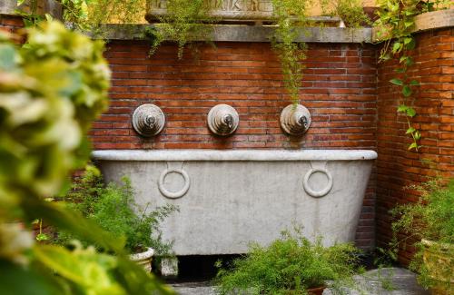 
a row of pots and pans sitting on top of a brick wall at Seven Kings Relais in Rome
