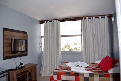 a bedroom with a bed with towels on it at Apartamento confortável in Goiânia