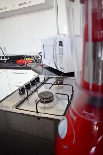 a kitchen with a stove and a red blender at Apartamento confortável in Goiânia