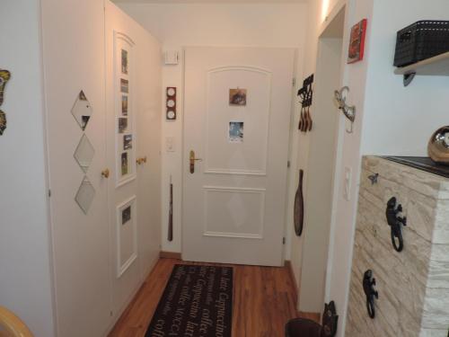 a hallway with white walls and a white door at Seegarten B (168 Be) in Lenzerheide