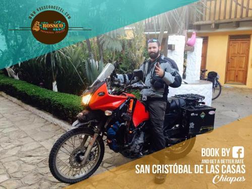 a man is sitting on a red motorcycle at Rossco Hostel & Hotel in San Cristóbal de Las Casas