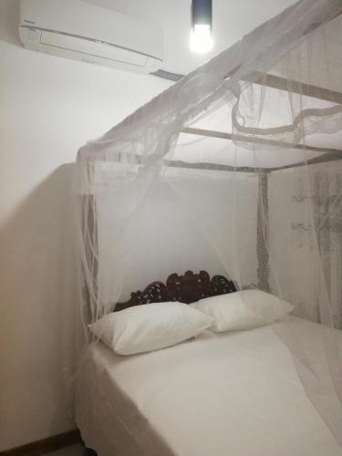 a white room with a bunk bed with two pillows at Air Port 5 Minutes Super Clean Upul in Negombo