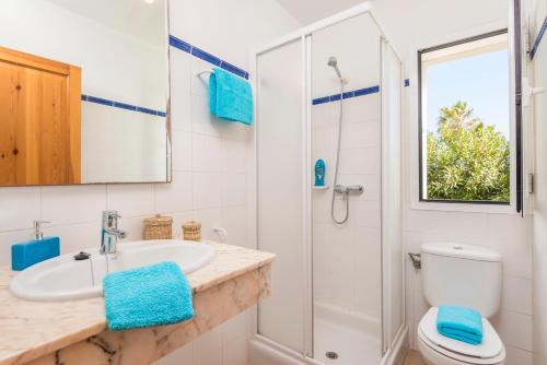 Un baño con inodoro, lavabo y ducha. en Villa Elena - Son Bou, en Son Bou
