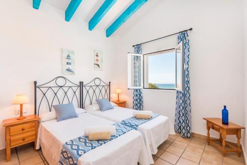 Dos camas en una habitación con ventana. en Villa Elena - Son Bou, en Son Bou