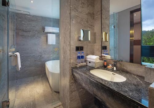 a bathroom with a sink and a tub and a shower at Grand Bay Hotel Zhuhai in Zhuhai