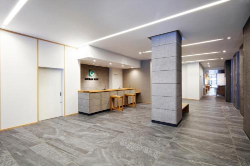 an office lobby with a reception desk and tile floors at karaksa hotel Sapporo in Sapporo