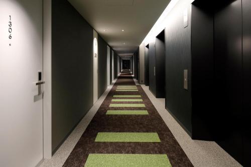 a hallway with green and black walls and a long aisle at karaksa hotel Sapporo in Sapporo