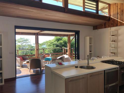 a kitchen with a view of a deck with a patio at La Villa Te Fetia Nui Moorea in Teavaro