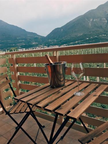 a wooden table with a bucket and a wine glass at Agriturismo Maso Miri in Trento